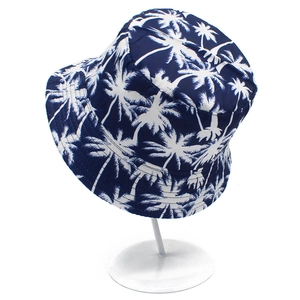 Navy blue bucket hat with white palm tree print on a display stand for outdoor sun protection