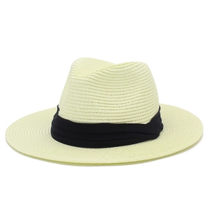 Detail of a beige Panama straw hat with a wide black pleated ribbon and fine weave texture
