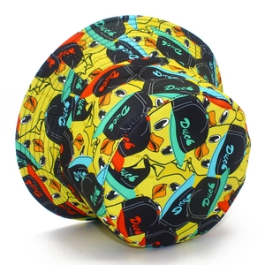 Yellow bucket hat with cartoon duck prints and street style graphics on white background