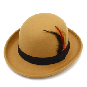 Detailed close-up of a camel felt bowler hat with a black band and classic feather accent