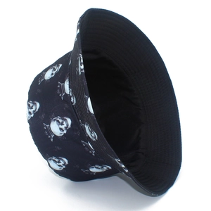 Detail of street style bucket hat with white skull and crown patterns on black fabric
