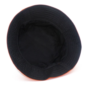 Detail of reversible fisherman hat showing black interior with orange brim stitching