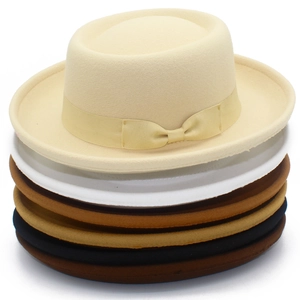 Close-up of stacked wool felt fedora hats with bow ribbons in six assorted neutral colors