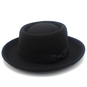 Detail of classic black wool pork pie hat featuring grosgrain ribbon and small bow