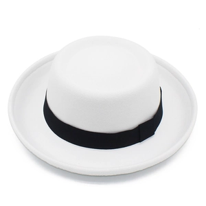 Dettaglio del cappello in feltro bianco con nastro in gros-grain nero su sfondo bianco