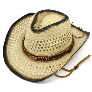 Detailed top view of light straw cowboy hat with dark brown spray effect and golden feather charm