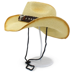 Detailansicht eines Cowboyhuts aus Stroh mit Lederband und metallischem Stierkopf