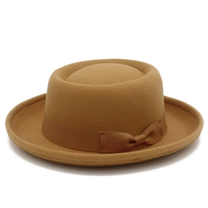 Detail of camel wool felt fedora hat featuring a smooth crown and matching bow ribbon