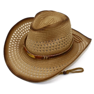 Detail of brown straw cowboy hat with golden feather metal charm and wooden beads