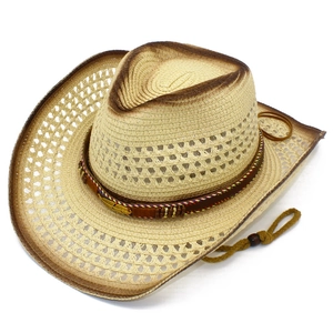 Close-up of woven cowboy hat featuring vintage feather charm and brown gradient brim