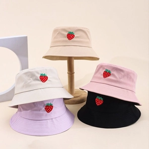 Dettaglio di cinque cappelli alla pescatora in cotone colorati con ricamo a fragola su supporti