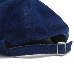 Detail of adjustable metal buckle and strap on denim newsboy cap with stitching