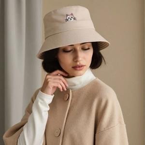 Close-up of minimalist cat embroidery on a beige cotton bucket hat for outdoor casual wear