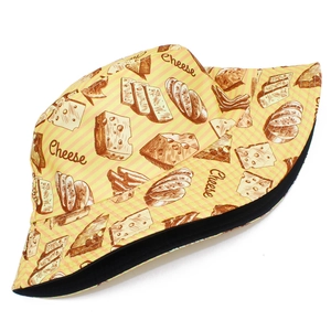 Detailed view of the cheese and bread print patterns on a yellow striped bucket hat