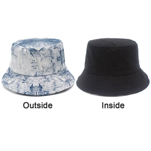 Detail view showing reversible bucket hat with blue tie-dye pattern and black solid side