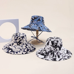 Detail of wide-brim sun hats with floral prints and adjustable windproof ropes