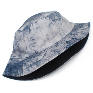 Detail view of double-sided bucket hat with blue tropical leaf patterns and black lining