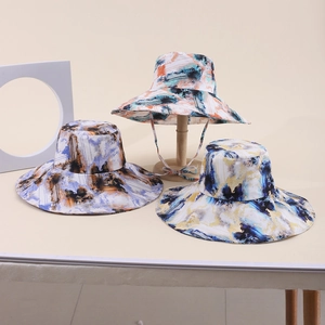 Dettaglio di cappelli da sole a tesa larga con stampe astratte e lacci antivento inclusi