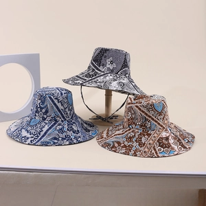 Dettaglio di tre cappelli da sole a tesa larga con motivi paisley e cordino antivento