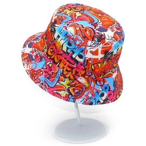 Bob coloré style graffiti avec motifs street art sur un présentoir blanc épuré