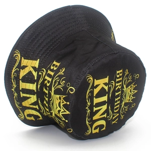 Detail of black birthday bucket hat featuring gold Birthday King text and crown pattern