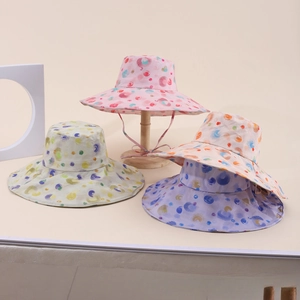 Dettaglio di quattro cappelli da sole colorati a pois per bambina con laccetti regolabili
