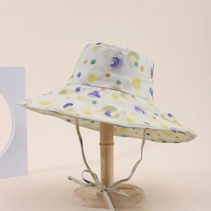 Dettaglio cappello a secchiello a tesa larga con pois colorati e laccetto antivento