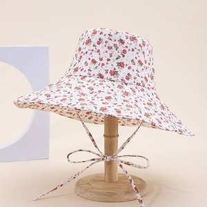 Detail of floral bucket hat with pink flower pattern and delicate ribbon bow on stand