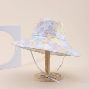 Dettaglio cappello parasole floreale a tesa larga con cordino antivento in tinta unita
