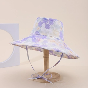 Dettaglio del cappello da sole a fiori viola con fiocco antivento in tinta abbinata