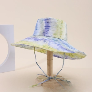 Dettaglio del cappello da sole tie-dye con tesa larga e cinturino antivento regolabile