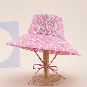 Detail of pink leopard print sun hat with adjustable ribbon tie on wooden display stand