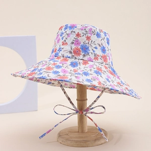 Detailed view of a floral wide-brim sun hat with blue and pink patterns and a matching ribbon