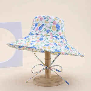 Detailed shot of a floral print cotton sun hat with chin strap on a wooden display stand