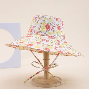 Classic floral pattern sun hat with straps on a wooden stand for a stylish summer look