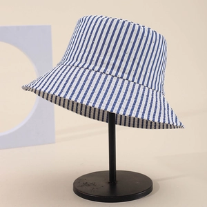 Cappello a secchiello a righe bianche e blu con strass su supporto nero da esposizione