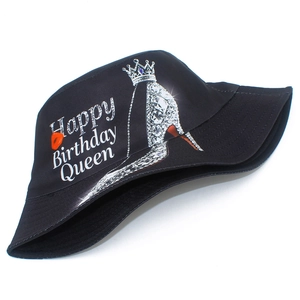 Detail of black birthday bucket hat featuring high heels, crown, and red lip print design