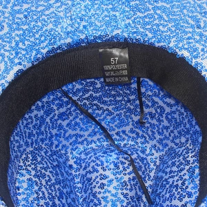 Detalle macro del interior del sombrero de vaquero con lentejuelas y etiqueta de talla 57
