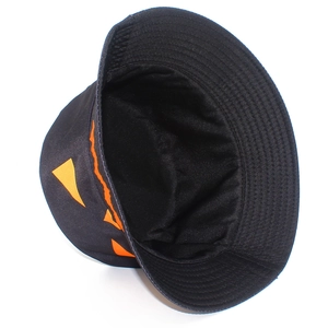 Detail view of the durable black cotton fabric and orange pumpkin face print on the bucket hat