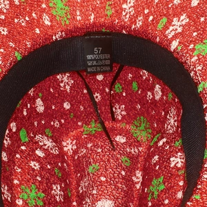 Detail of red snowflake Christmas hat showing internal sweatband and 100% polyester label