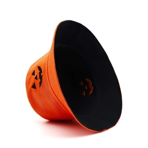 Détail du chapeau réversible d'Halloween avec couches orange et noires et visage de citrouille