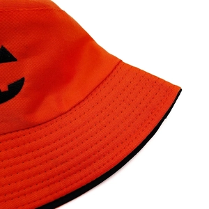 Gros plan du chapeau bob en coton orange avec visage de citrouille d'Halloween brodé