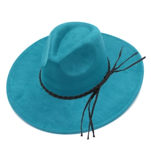 Detail view of teal faux suede fedora featuring black braided rope and long tassels