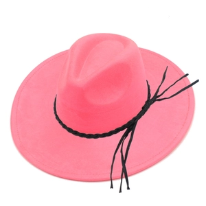 Detail of rose red wide brim fedora hat featuring black braided cord and tassel fringe