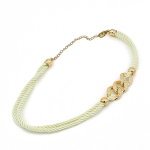 Close-up of woven rope necklace with textured gold rings and lobster clasp