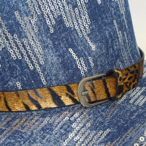 Detailed close-up of blue denim jazz hat featuring silver sequins and leopard print belt