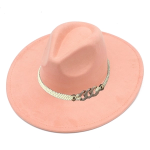 Close-up of salmon pink suede fedora hat with white rope band and gold diamond chain
