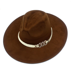 Detail of dark brown fedora hat featuring white braided rope and golden chain trim