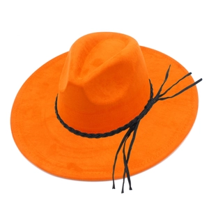 Detail view of orange suede fedora hat with wide brim and black braided tassel band