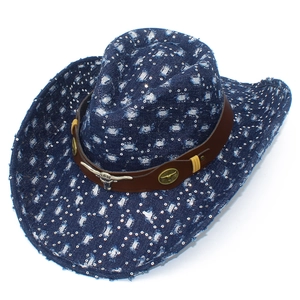 Detail of blue denim cowboy hat with distressed holes, sequins, and metal bull emblem